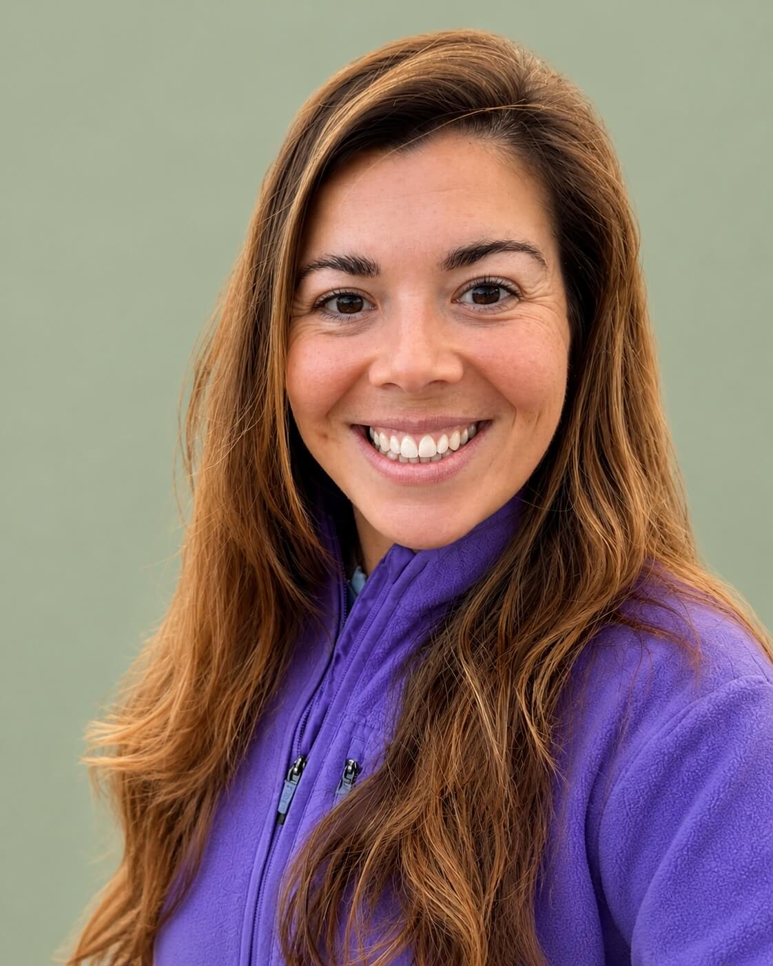 Holly Eastlake smiling against a soft green background.